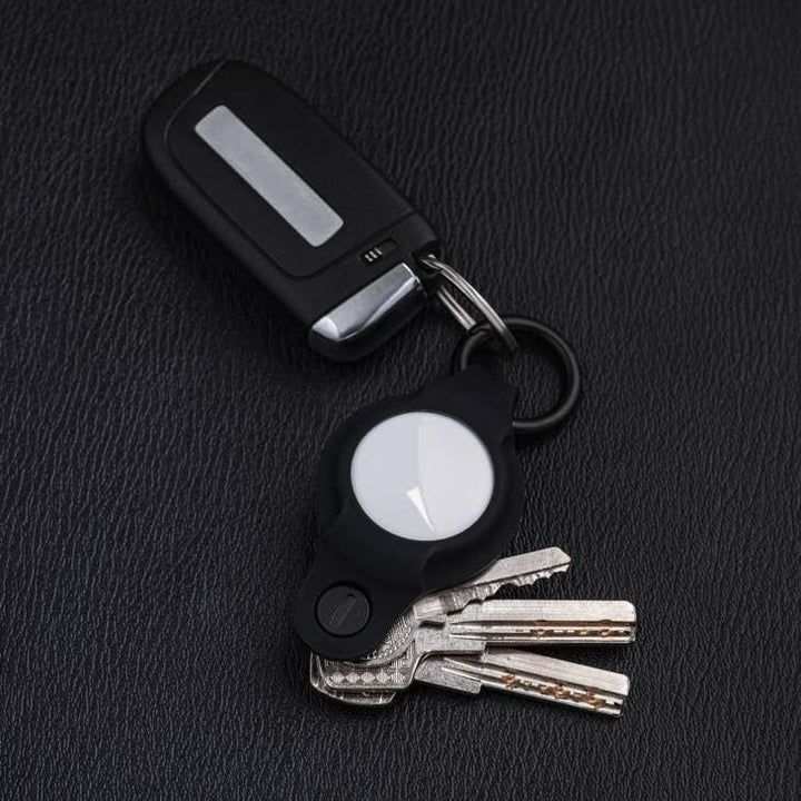 Autoschlüssel mit Schlüsselfinder und mehreren Schlüsseln auf schwarzem Leder