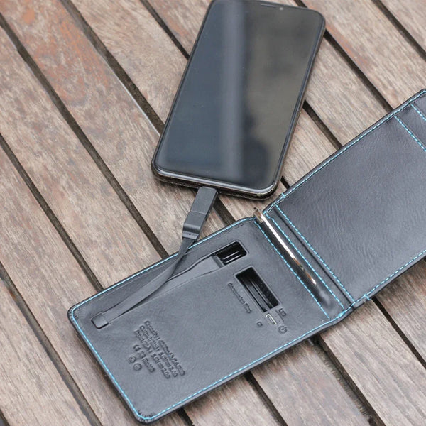 Schwarzes Lederetui mit Powerbank lädt Smartphone auf Holztisch