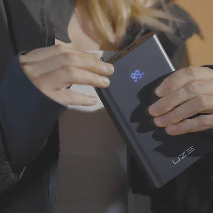 Person hält UZE Powerbank mit LED-Anzeige, tragbares Ladegerät, 92 Prozent Ladestand