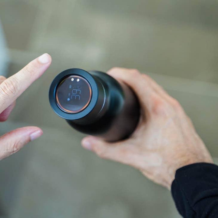 Hand hält schwarze Thermosflasche mit digitalem Temperaturdisplay, Touch-Funktion