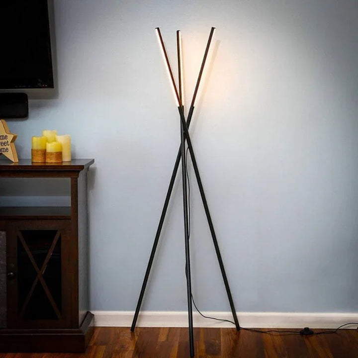 Moderne Stehlampe mit drei schlanken LED-Stäben im Wohnzimmer auf Parkettboden