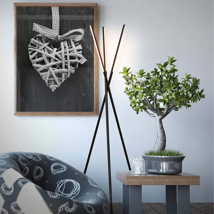 Moderne Stehlampe, Kunstpflanze und abstraktes Herzbild in stilvollem Wohnzimmer