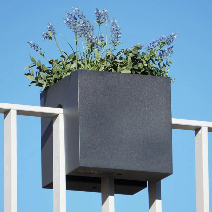 Moderner schwarzer Blumenkasten Cube auf Balkon-Geländer mit Lavendel, blauer Himmel