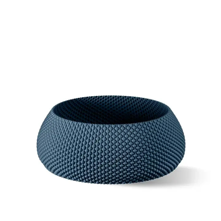 Eine strukturierte, dunkelblaue Schüssel mit einem einzigartigen Wabenmuster vor einem sauberen weißen Hintergrund.