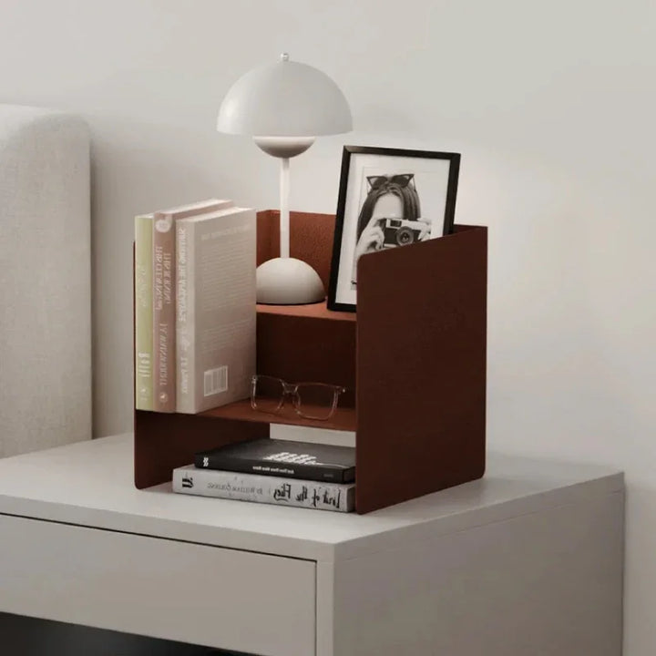 Schreibtisch mit braunem Buchhalter, Büchern, Lesebrille, Lampe und gerahmtem Foto