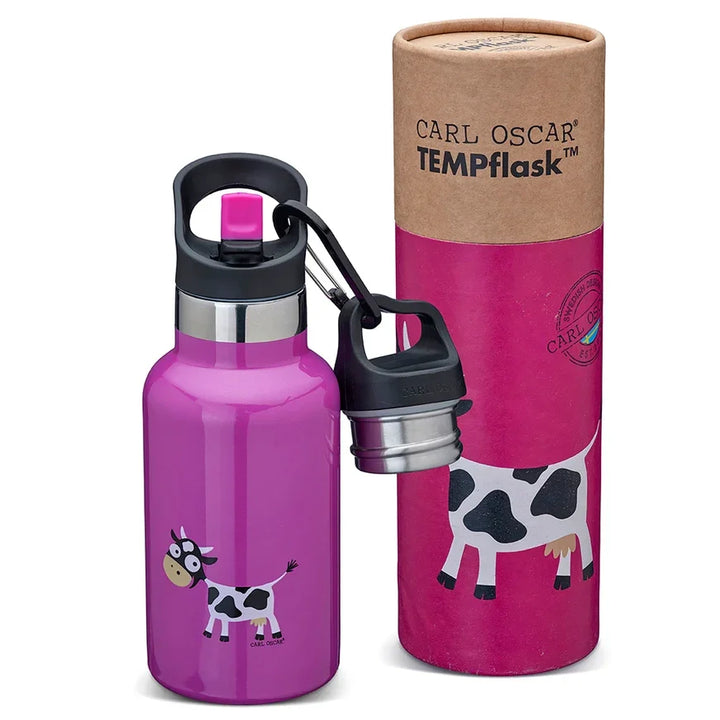 Eine leuchtend rosa Wasserflasche mit Kuhmotiv und dazu passender Kartonverpackung mit der Aufschrift „CARL OSCAR TEMPflask“.