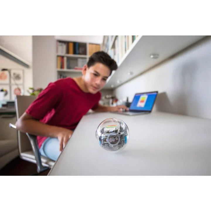 Jugendlicher programmiert Sphero Roboterball am Laptop in modernem Arbeitszimmer