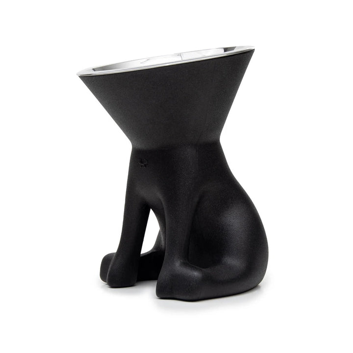 Ein skurriler, schwarzer, hundeförmiger Napf mit konischer Oberseite und glänzend silbernem Innenraum, der auf einem weißen Hintergrund steht.