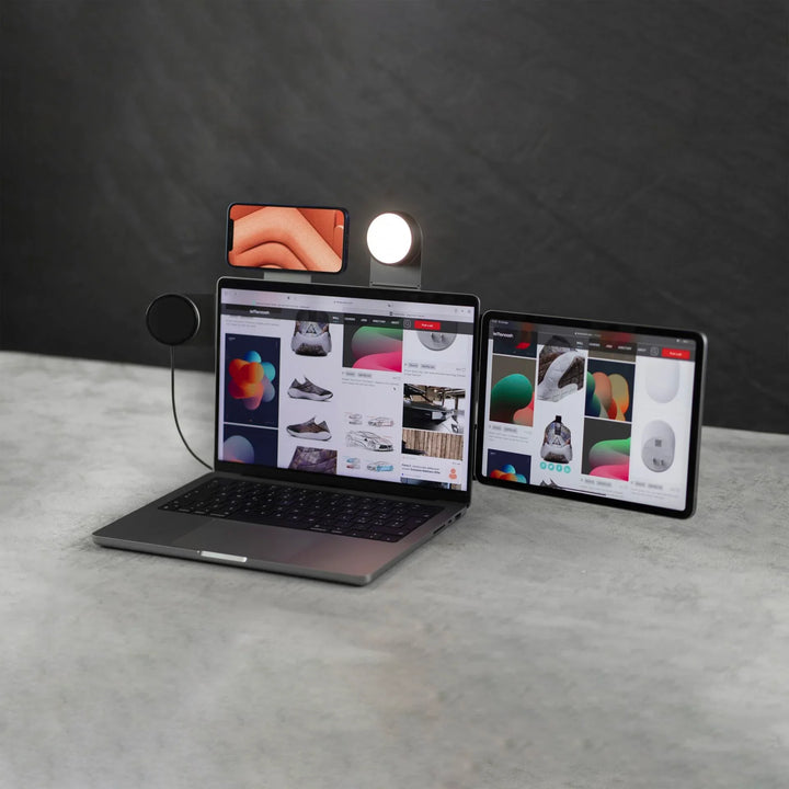 Laptop mit angebrachtem Smartphone-Halter, Ringlicht und externem Tablet, modernes Schreibtisch-Setup