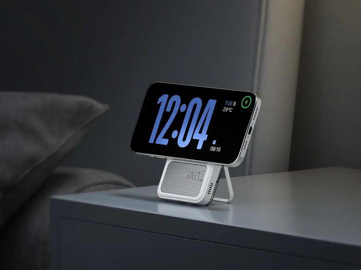 Smartphone auf wireless Powerbank mit Ständer auf Nachttisch, großes digitales Display