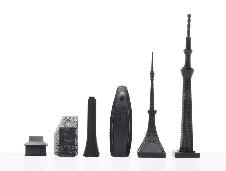 Schwarze Tokyo Schachfiguren als Architekturmodelle vor weißem Hintergrund