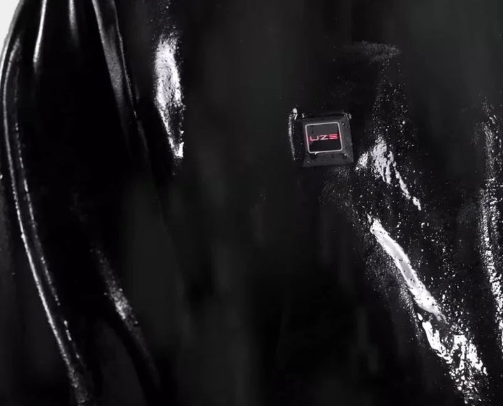 Schwarze UZE Jacke, wasserabweisend mit Nässe-Effekt und UZE Logo, Nahaufnahme