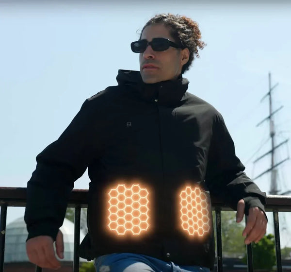 Mann mit schwarzer beheizter Tech-Jacke mit leuchtenden Heizelementen im Freien